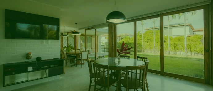 Modern dining room with large windows overlooking a garden.